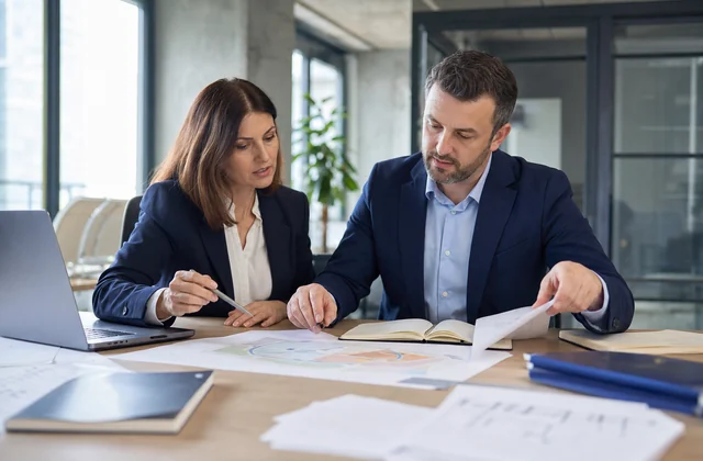 O consultantă și un consultant discută un proiect profesional